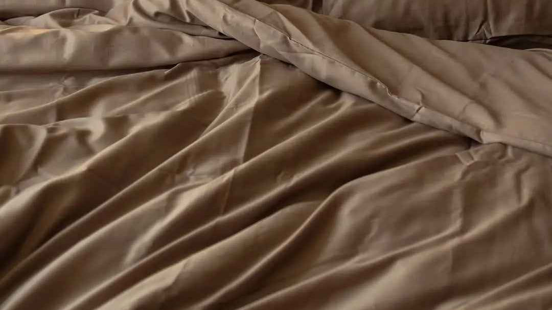 Pościel z satyny bawełnianej na łóżku, idealna do komfortowego snu w stylowej sypialni.